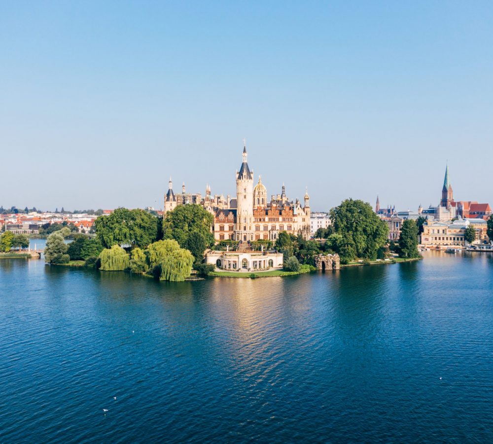 Vieltürmige Schönheit: Das Schweriner Schloss liegt auf einer Insel im Schweriner See. Mitte des 19. Jahrhunderts ließ Großherzog Friedrich Franz II. die Residenz von Schwerin zu einem Neorenaissance-Palast umbauen. // Multi-towered beauty: Schwerin Palace is situated on an island in Lake Schwerin. In the mid-19th century, Grand Duke Friedrich Franz II had the Schwerin residence converted into a neo-Renaissance palace.