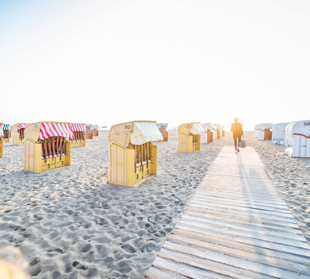 Frau läuft über Dielen am Strand © LTM